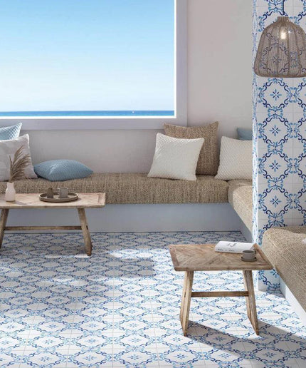 Living room with beige sofas, wooden coffee table, and decorative pillows with a patterned wall and ocean view.