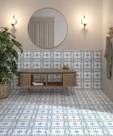 Foyer with patterned blue and white tiles, wicker furniture, and plants.