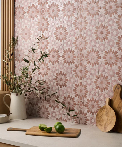 Kitchen counter with cutting board, limes, and pitcher against a patterned wall.