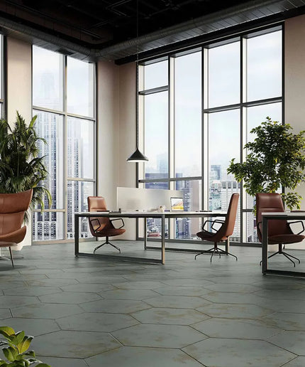 Modern office space with large windows, desks, and chairs.