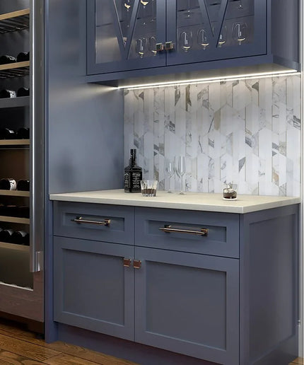 Modern kitchen with blue cabinets, marble backsplash, and wine storage.