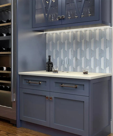 Modern kitchen with blue cabinets, white countertop, and geometric backsplash.