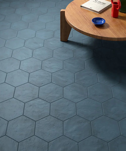 Hexagonal blue tiles on a floor with a wooden table and items on it.