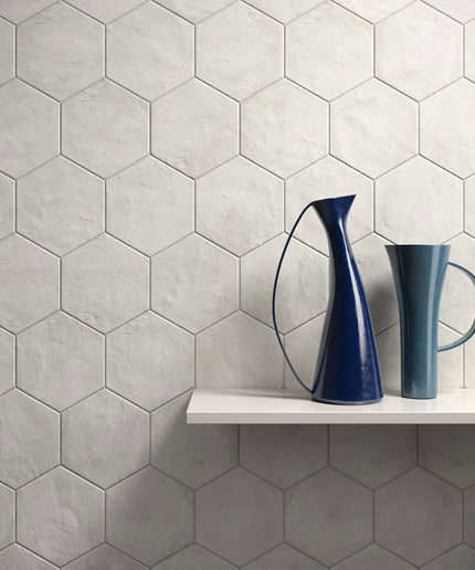 Hexagonal tiles with a shelf and two blue ceramic vases.