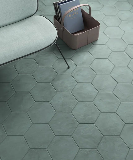 Hexagonal green tiles on a floor with a sofa and basket in the background