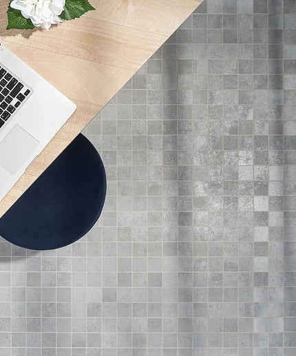 Laptop on a wooden desk with a gray tiled floor