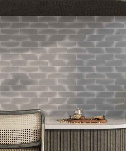Gray brick-patterned wall with a table and chairs in a modern interior setting.