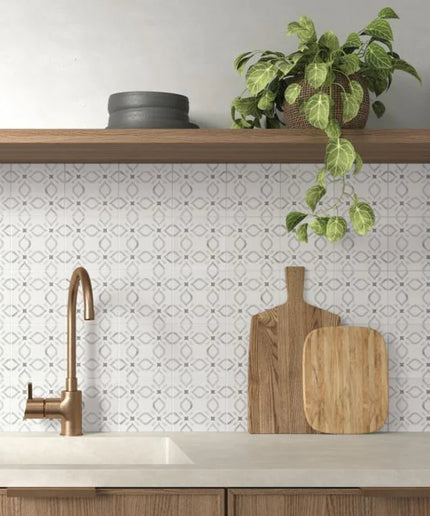 Modern kitchen with a sink, wooden cutting board, and plant on a shelf.