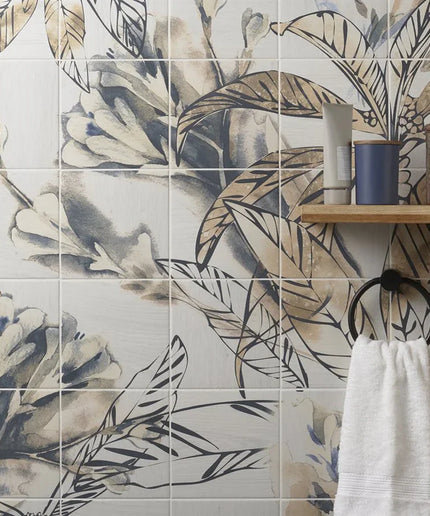 Bathroom with floral-patterned tiles and a towel hanging on a hook.