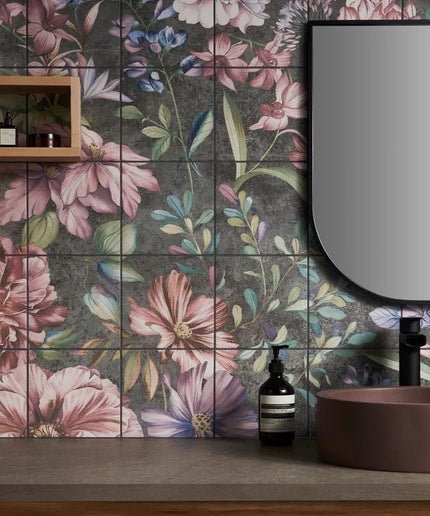 Bathroom with floral tiles, a mirror, and a sink.