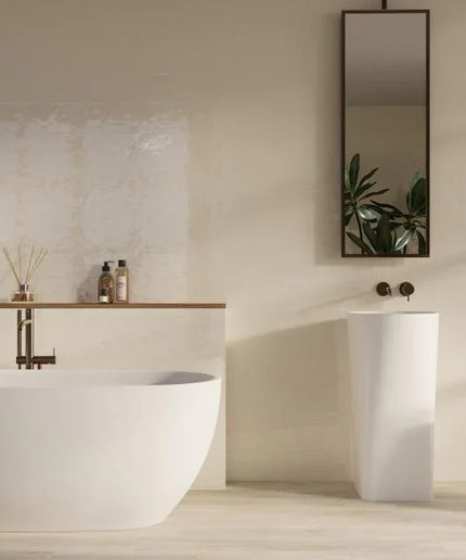 Modern bathroom with a freestanding bathtub, sink, and decorative elements.