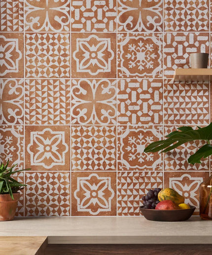 Patterned tiles on a wall with decorative elements and plants.