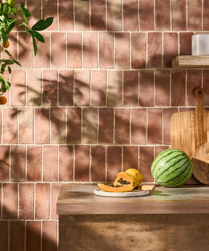 Kitchen counter with fruits against a tiled wall