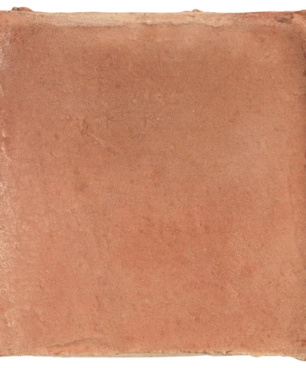 Square terracotta tile with a rough texture on a white background