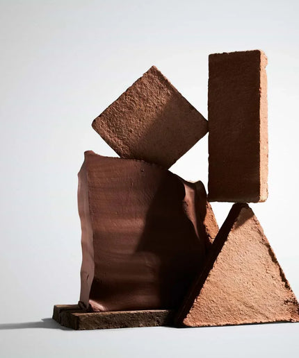 Abstract sculpture made of brown rectangular blocks on a light gray background