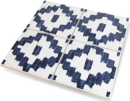 Four ceramic tiles with blue and white pattern on a white background