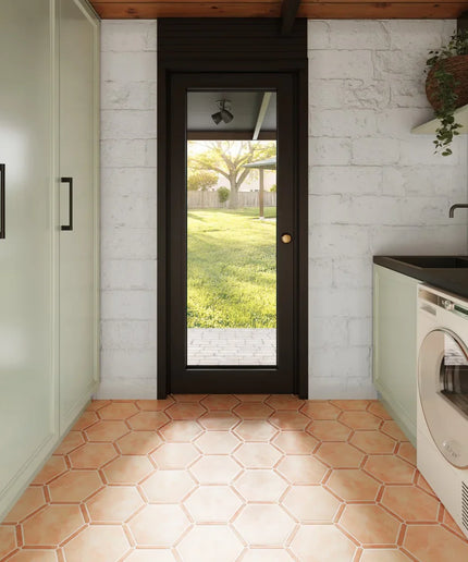 Modern laundry room with hexagonal tiles, washer, dryer, and a door leading outside.