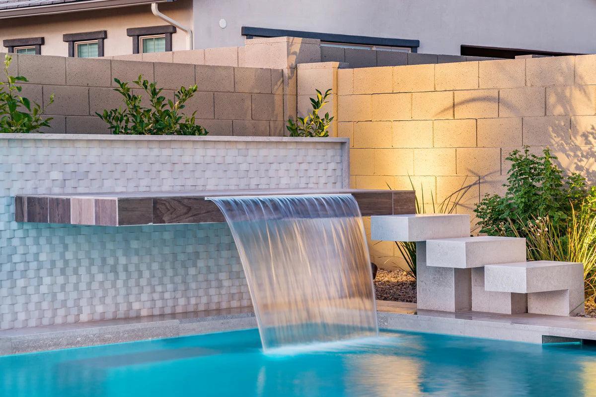 Waveline glass mosaic tile from Island Stone in a swimming pool, showing a textured, iridescent blue surface that mimics the movement of water.