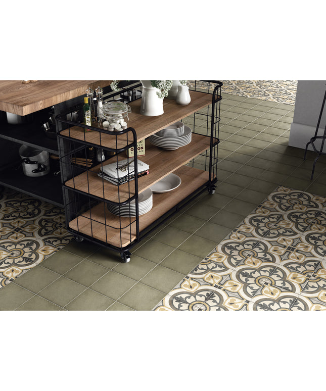 A three-tier rolling utility cart with a black metal frame and light brown wooden shelves, styled in a kitchen setting with plates, vases, and kitchenware on a tiled floor.