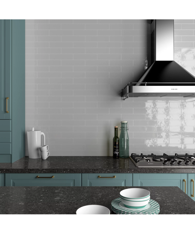 Modern kitchen backsplash with glossy gray subway tiles, teal cabinets, and black countertop