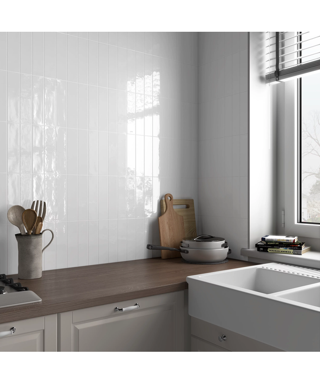 Glossy white vertical kitchen backsplash tiles above wood countertop and farmhouse sink