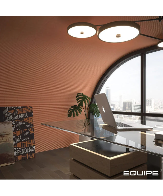 A modern office interior with a curved terracotta wall, large arched window overlooking a city skyline, a glass desk with a laptop, a potted plant, and a framed poster on the floor. The word EQUIPE appears in the bottom right corner.