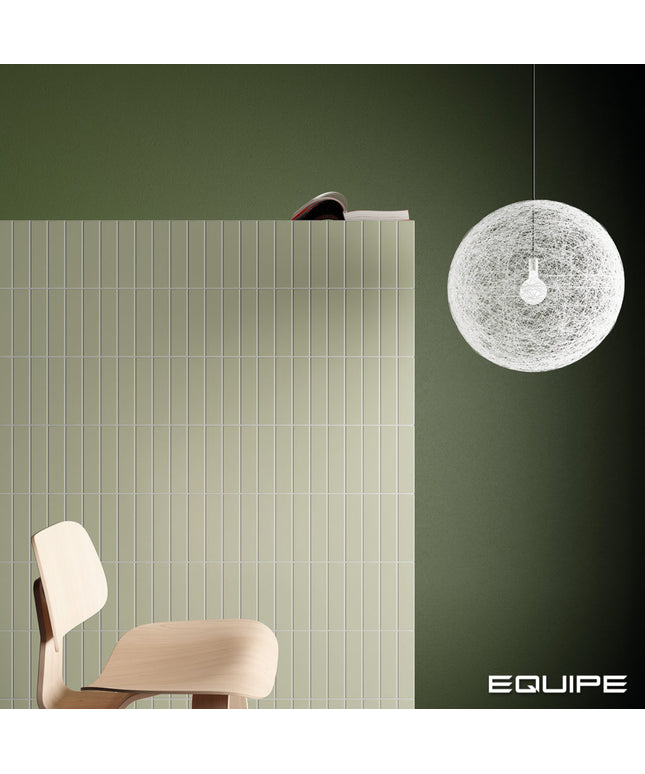A modern interior scene with a dark olive green wall, a white spherical woven pendant light hanging on the right, a light wood chair at lower left, and a large white slatted panel behind the chair. The word EQUIPE appears in the bottom right corner.
