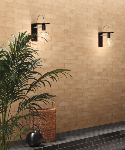 Modern wall lights on a beige tiled wall with a plant and decorative basket.