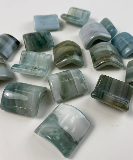 Curved glass mosaic tiles in blue and green tones on white background, ideal for backsplash or accent walls.