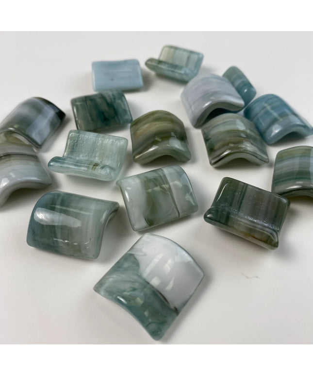 Curved glass mosaic tiles in blue and green tones on white background, ideal for backsplash or accent walls.