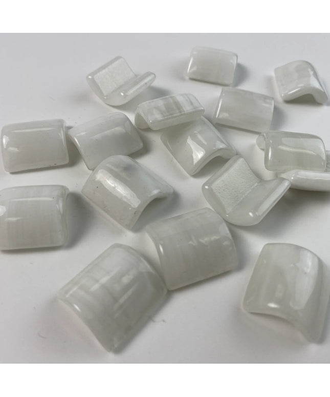 Glossy white curved glass mosaic tiles on a plain background, ideal for backsplash or bathroom decor.