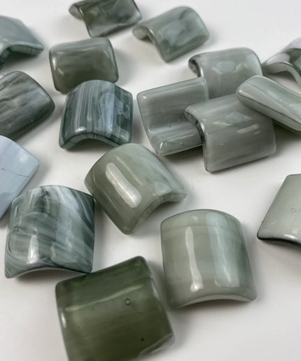 Curved, glossy green mosaic glass tiles for kitchen backsplash or bathroom decor.