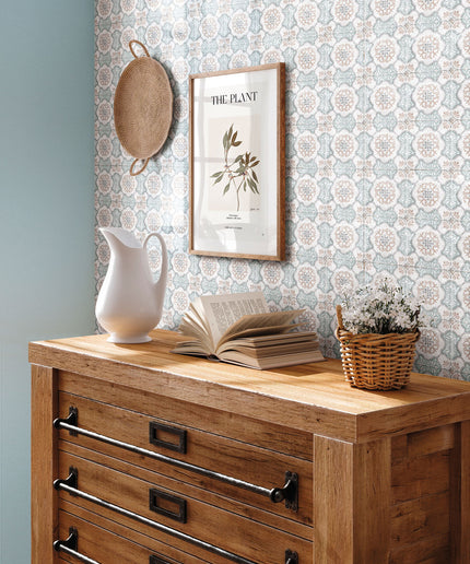 Patterned ceramic wall tile backsplash behind rustic wood dresser with decor in natural light