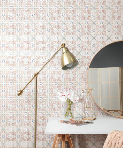 Geometric patterned wall tiles in a vanity area with a round mirror and gold lamp
