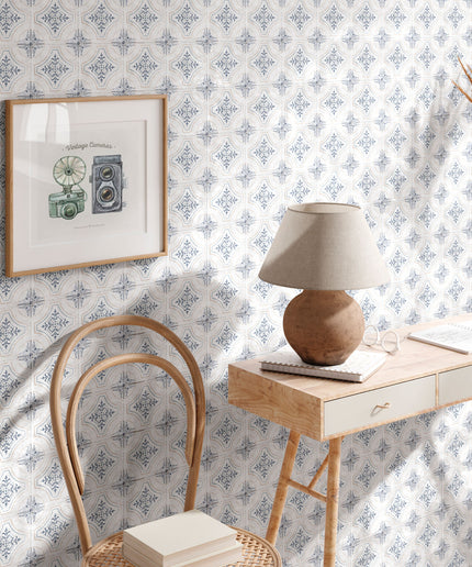 Blue and white patterned wall tiles in a cozy study with wooden desk, chair, and table lamp.