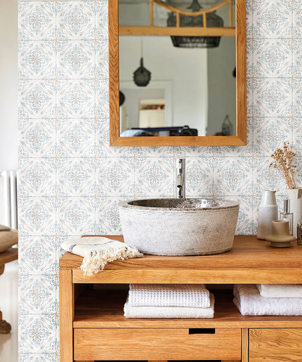 Bathroom with patterned wall tiles, wooden vanity, stone sink, and mirror above the sink.