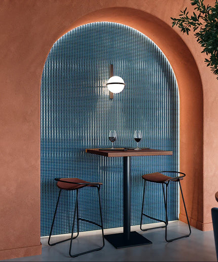 Bevel_Saphire_Gloss-walls Modern interior with pink walls, a blue tiled wall, and a small table with two chairs.