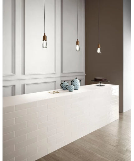 Modern kitchen with glossy white subway tile counter, pendant lights, and ceramic decor