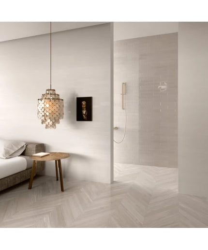 Modern bedroom with light herringbone floor tile, pendant lamp, and open shower area