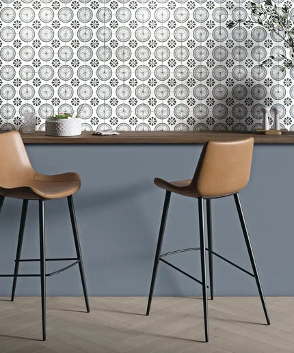 Modern kitchen backsplash with patterned ceramic tiles and two brown bar stools