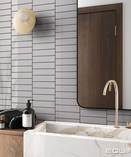 Modern bathroom with marble bathtub, gold faucet, and wooden cabinet.