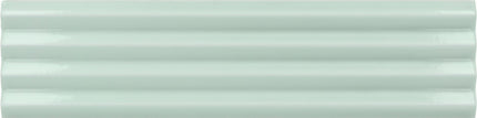 A close-up of a glossy, pale mint green ceramic tile with horizontal grooves.