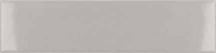 A rectangular glossy ceramic subway tile in a light warm gray or greige color, shown flat against a matching background.