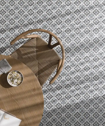 Black and white patterned floor tiles beneath a round wooden table and chair