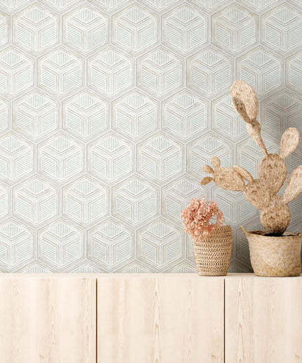 Geometric hexagon tile wall in light tones with woven baskets on a wood cabinet