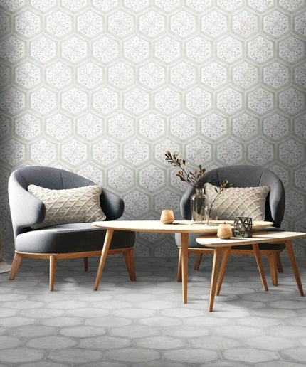 Modern living room with gray hexagon tile wall and floor, two armchairs, and coffee tables