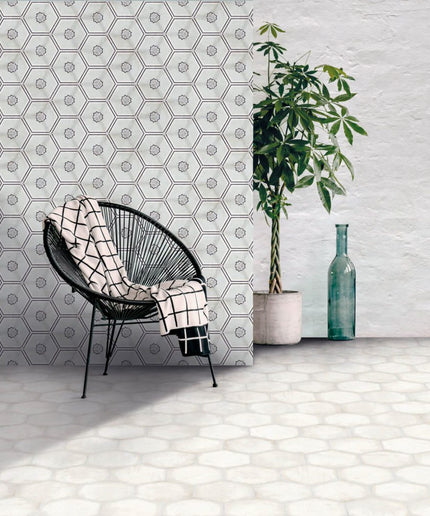 Modern room with white hexagon tile wall and floor, black chair, potted plant, and glass vase