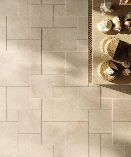 Beige tiles with a geometric pattern and a table with decorative items in the corner.