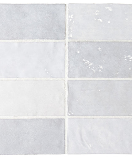 Six rectangular ceramic subway tiles arranged in a 3-by-2 grid, featuring various finishes including matte, glossy, and textured in light gray and white tones.
