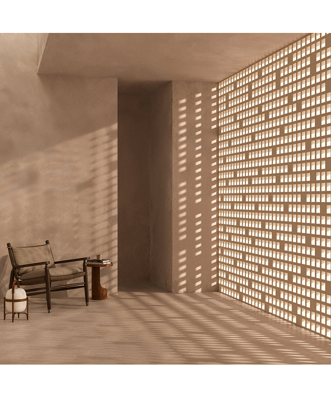 Modern interior with a chair and small table near a textured wall with light filtering through.